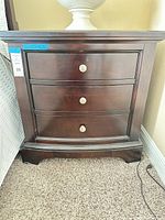 Front view of nightstand showing three drawers and knobs