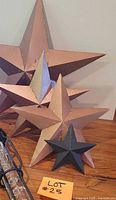 All four metal stars grouped on wood surface with lot tag