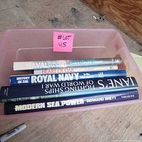 Top view of all five books stacked in bin showing spines and titles