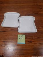 Two white toast-shaped porcelain plates on table