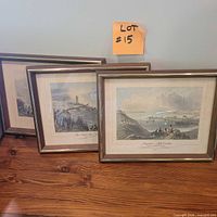 Three framed prints standing on table