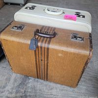 Two vintage suitcases, brown Monarch in front, off-white Red Cap behind