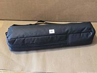 closed black zippered travel bag likely containing tripod