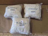 Three sealed Subrtex chair cover packs displayed on cardboard background