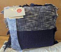 Front view of pillow showing plaid design and fringe