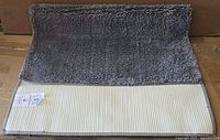 Bath rug folded to show pile and backing