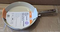 Top view of Anko 32 cm cream ceramic fry pan with tag attached