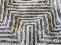 Close-up of rug pattern showing concentric design and pile texture