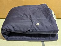 Folded navy comforter, top view showing quilting and folded size