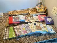 Overview of all napkin packs lined on countertop with three wicker baskets