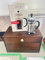 Bodum French press, retail box, and wooden bread box