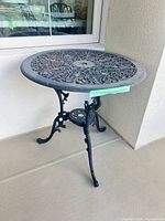 Full view of cast iron bistro table against wall