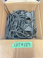 Box showing coiled black ropes and metal pulley brackets