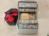 Open toolbox with trays extended showing tools and Husky bag beside