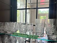 Full set of crystal glasses on shelf with counts label visible