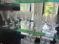 Wine glasses and brandy snifters on glass shelf