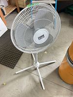 Front view showing full pedestal fan and brand logo