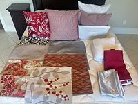All pillow covers, inserts, mattress protector, bed skirt and pillowcases laid out on mattress
