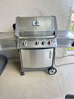 Front view of Napoleon Prestige 450 grill, hood closed, side shelves visible