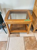 Front view of oak end table showing glass top and cane shelf