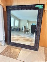 Full view of mirror leaning against wall
