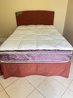 Complete bed setup showing headboard, topper, mattress, box spring, skirt