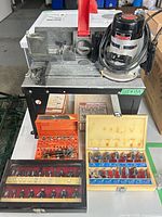 Overall view of router on table with three bit sets in cases