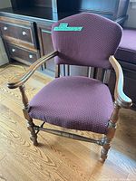 Full front view of burgundy upholstered wooden armchair