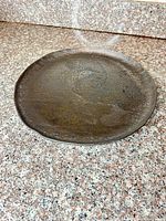 Top view of bronze charger showing overall surface texture