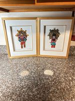 Both framed Kachina artworks side by side