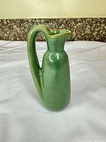 Front view of green ceramic pitcher vase