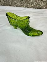 side view of green pressed glass shoe