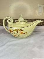 Right side view of teapot showing floral motif and overall shape
