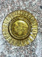 Top view of amber glass ashtray showing ribbed edge and etched logo