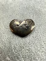 Front view of brooch showing heart shape and bird motif