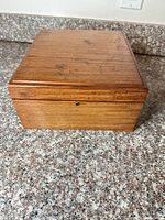 Closed wooden flatware box front view showing lock and wood grain