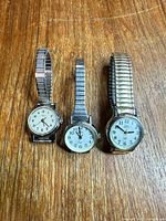 Three Timex watches side-by-side on wood surface