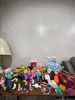 Tabletop view of entire assortment of plush, figures, electronic toy, accessories