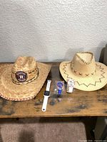 Both cowboy hats and three watches on table