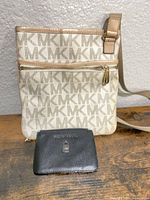 Front view of beige MK monogram crossbody bag and black coin pouch