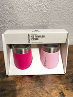 Front of retail box showing two tumblers, magenta and light pink