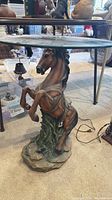 Full view of table showing horse base and glass top