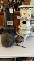 Overall view of both heaters, kettles and spoon on table