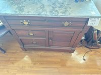 Front view showing marble top, drawers, cabinet door, hardware