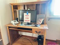 Front view of brown oak tone computer desk showing hutch, keyboard tray, drawer