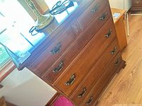 Front view showing five drawers and brass handles