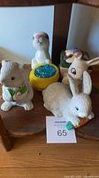 Group of four ceramic rabbit figurines on shelf