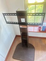 Full view of dark brown floor TV stand with metal bracket attached