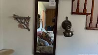 mirror, sconce and floral shelf mounted on wall