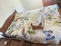 Bed frame assembled with quilt on mattress, box of lace linens on top